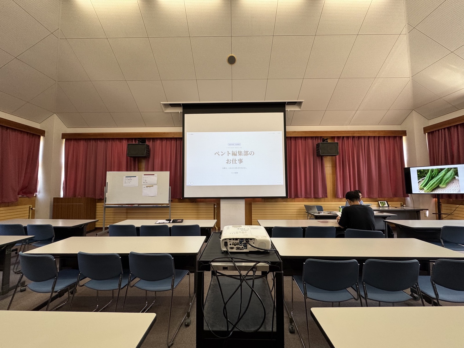 出石中学校での講演の様子（スクリーンに「ペント編集部のお仕事」）